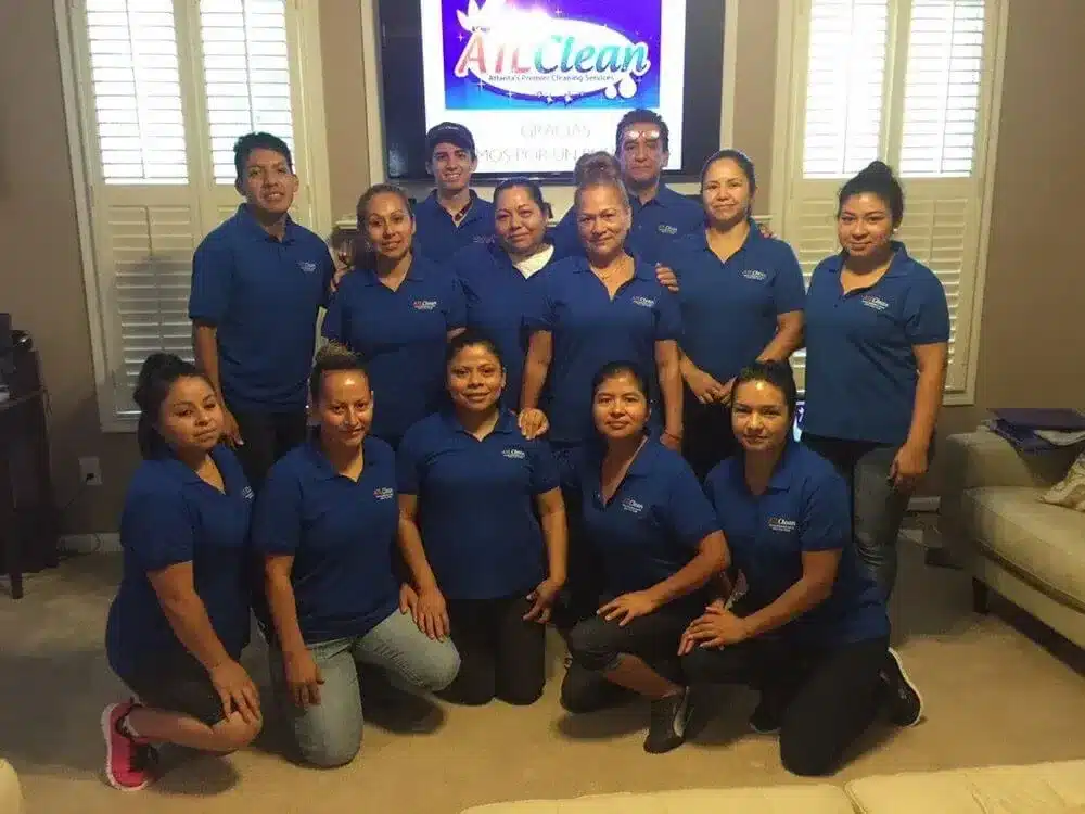 The ATL Clean cleaning team in navy company polos, gathered in a client's living room